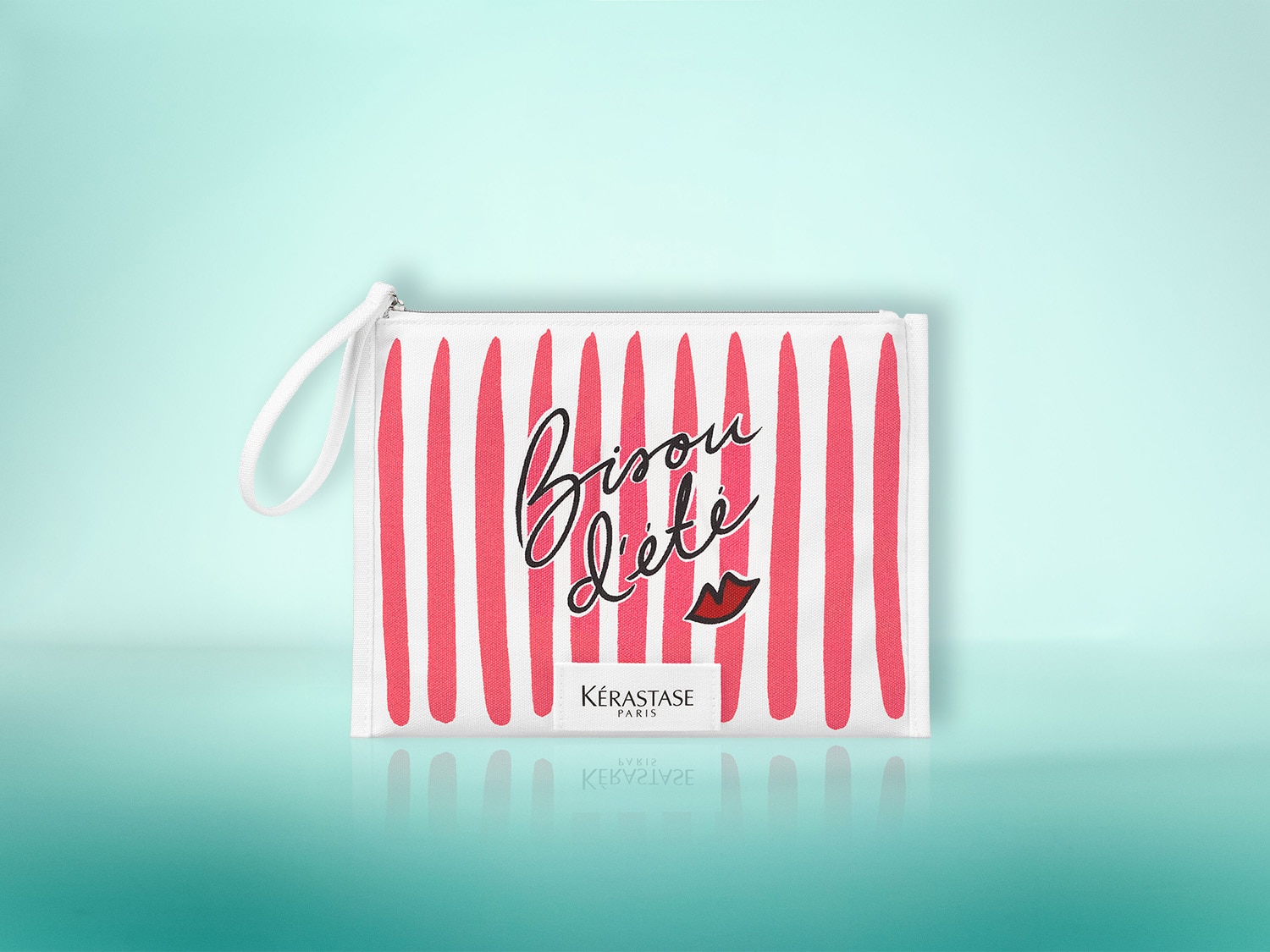 Die weiße Kosmetiktasche mit roten Streifen und der Aufschrift "Bisou d'été" sowie einem roten Kussmund-Logo ist ein stilvolles Accessoire für Ihre Beauty-Produkte.