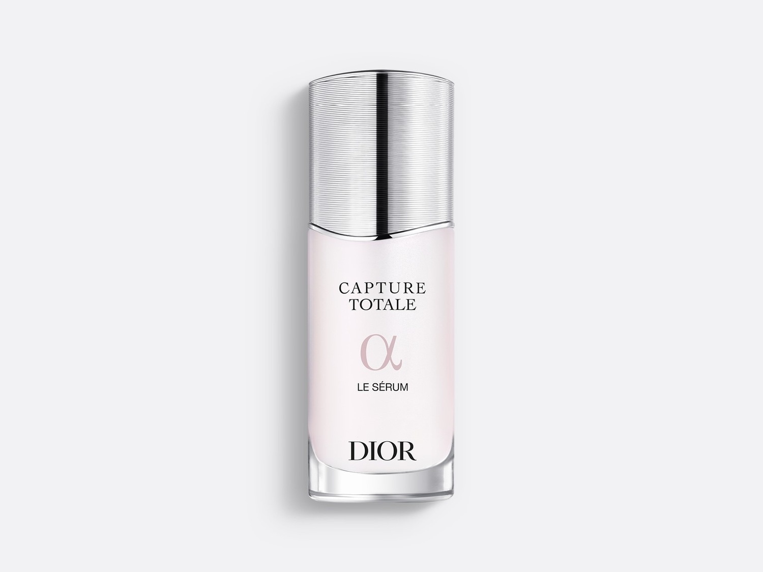 Le sérum Capture Totale Le Sérum de Dior est présenté dans un flacon en verre transparent avec un capuchon argenté, le liquide rose pâle visible à travers le verre.