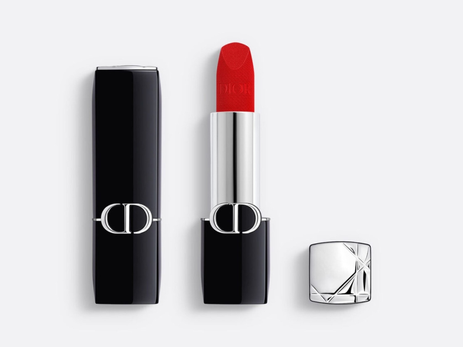 Le rouge à lèvres Dior Rouge Forever, présenté dans un élégant étui noir avec le logo CD argenté, révèle une teinte rouge vif et une texture mate, avec son capuchon argenté à motifs géométriques posé à côté.