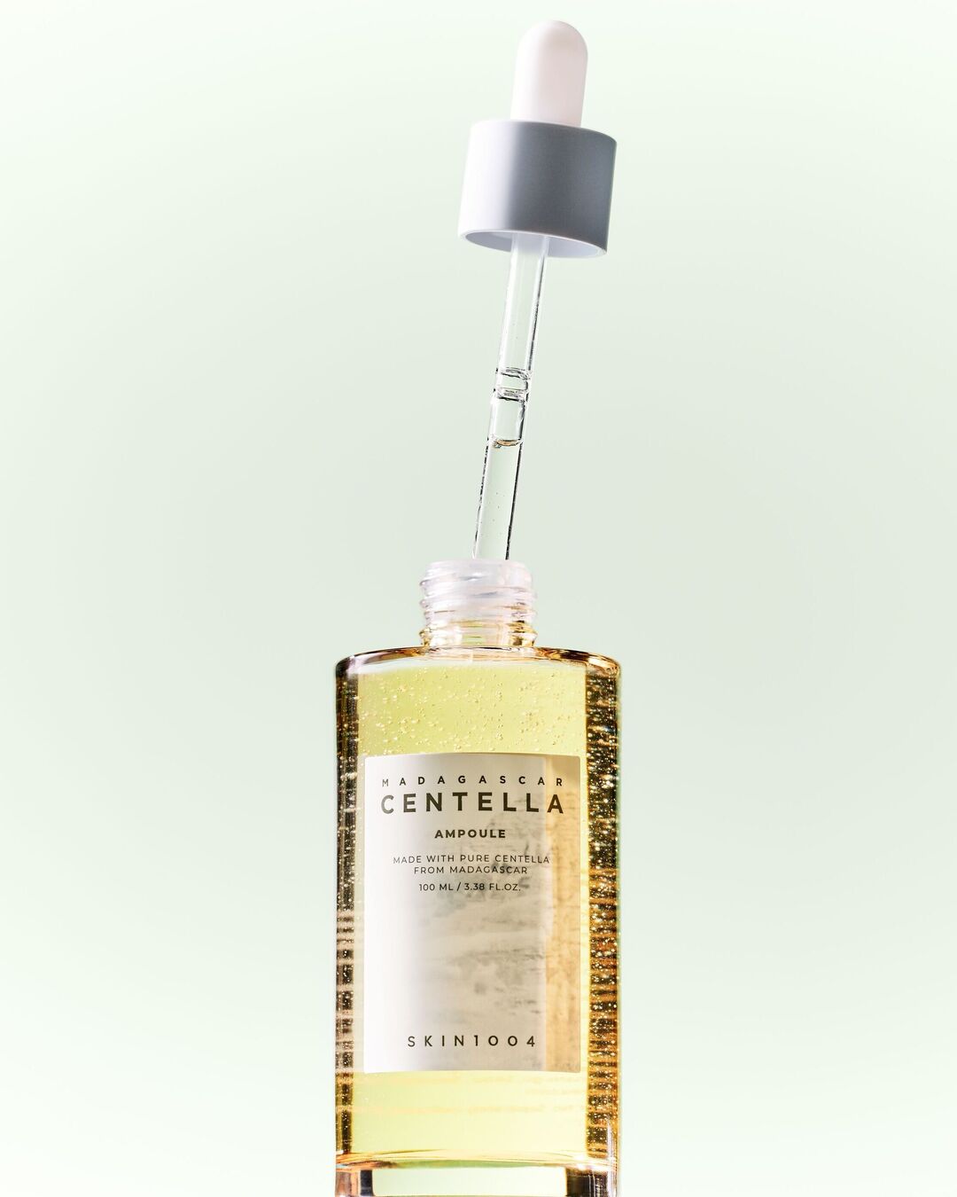 Le sérum Madagascar Centella Ampoule de SKIN1004, présenté dans une bouteille en verre transparent avec une pipette, contient 100 ml d'ampoule de centella pure de Madagascar.