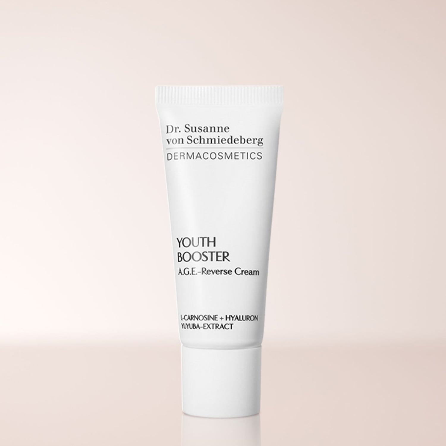 Die Dr. Susanne von Schmiedeberg DERMACOSMETICS YOUTH BOOSTER A.G.E.-Reverse Cream in einer weißen Tube enthält L-Carnosine, Hyaluron und Yuyuba-Extrakt für eine jugendlichere Haut.