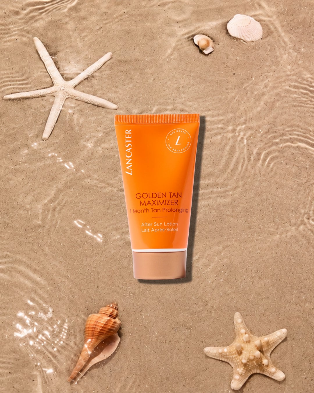 Die Lancaster Golden Tan Maximizer After Sun Lotion in einer orangefarbenen Tube mit beiger Kappe, umgeben von Muscheln und Seesternen auf nassem Sand, verspricht eine einmonatige Bräunungsverlängerung.