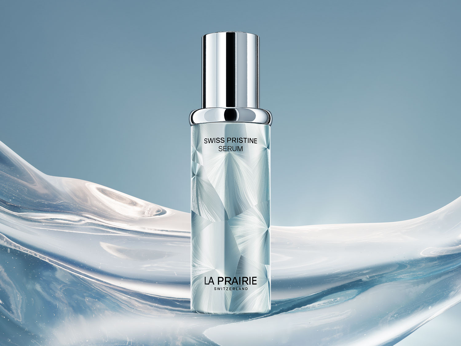 Das La Prairie Swiss Pristine Serum in einem eleganten, zylindrischen Flakon mit silbernem Verschluss und einem schimmernden, eisblauen Design, das an gefrorene Kristalle erinnert, steht auf einem hellblauen Hintergrund mit fließenden, wellenförmigen Elementen.