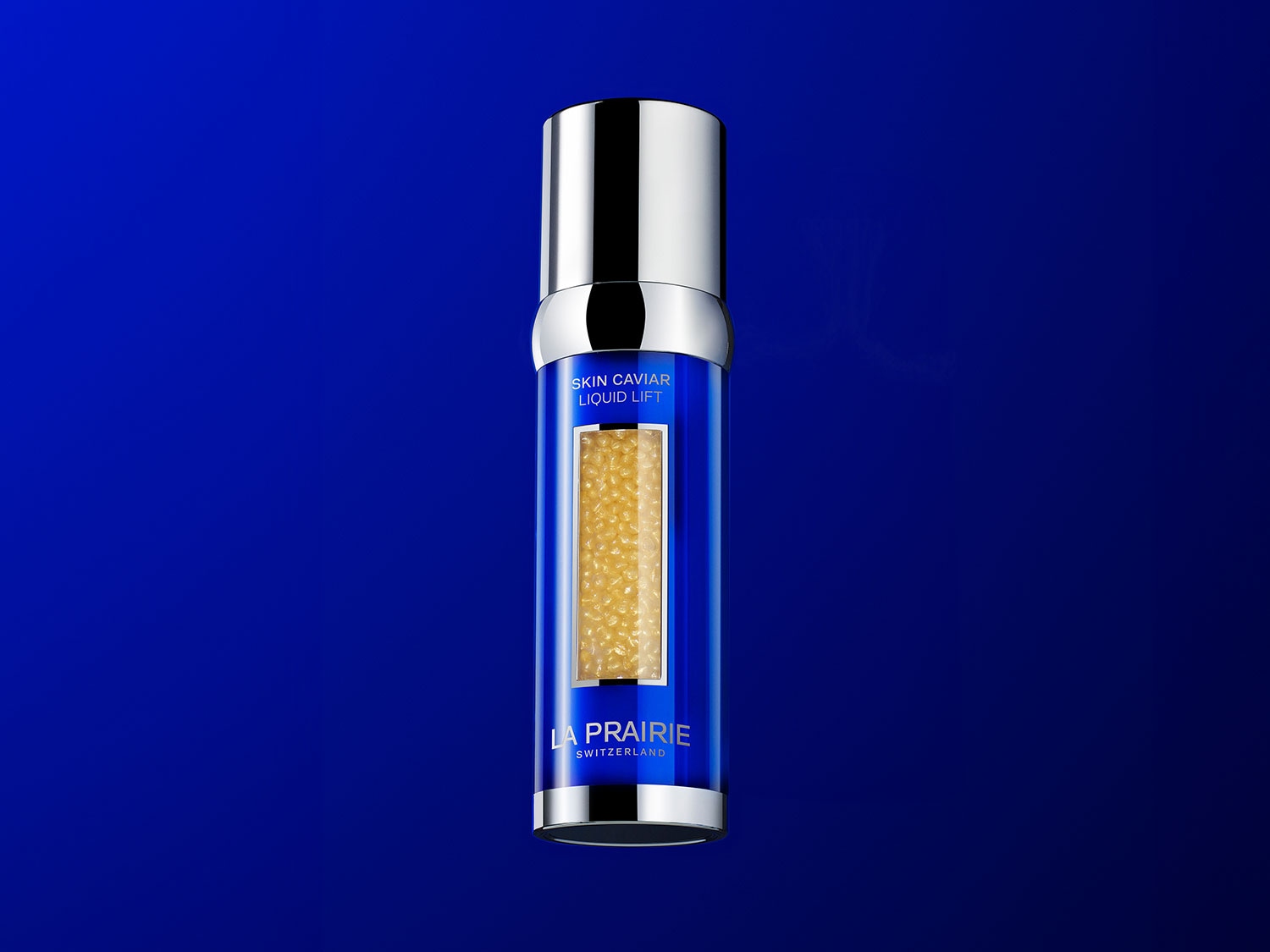 Die La Prairie Skin Caviar Liquid Lift ist ein blaues Serum mit goldenen Kaviarperlen in einem eleganten Flakon mit silbernem Verschluss, das für ein jugendlicheres Aussehen sorgt.