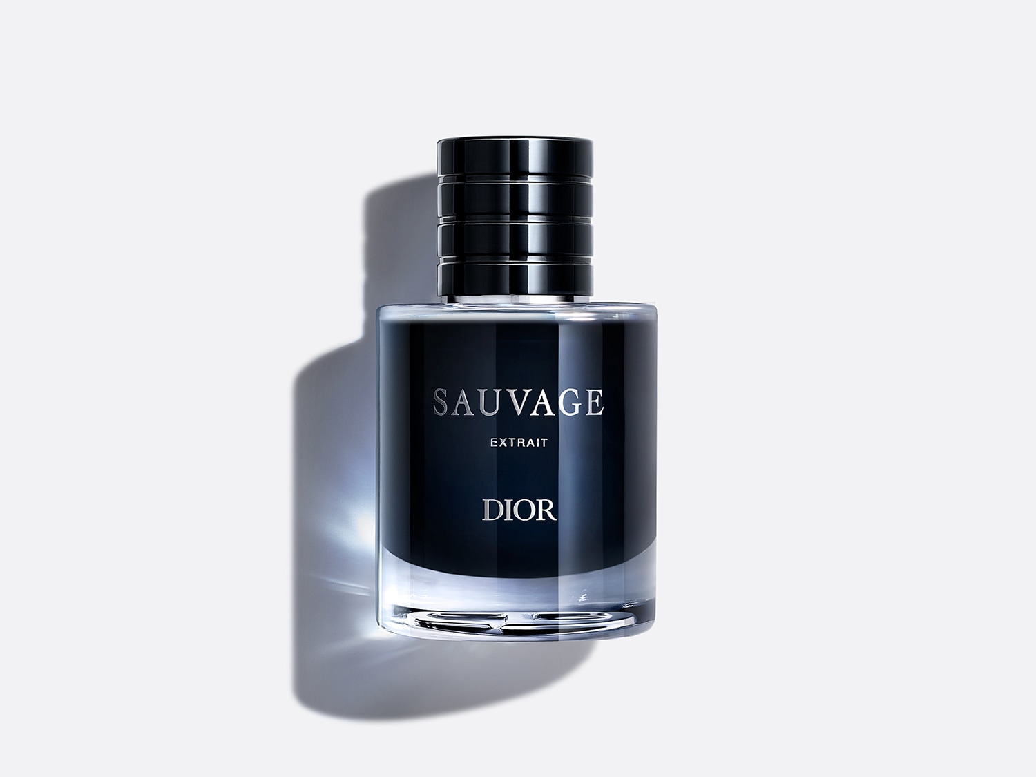 Le parfum Dior Sauvage Extrait est présenté dans une bouteille en verre transparent avec un liquide bleu foncé, un capuchon noir et les noms "SAUVAGE" et "DIOR" écrits en blanc sur l'étiquette.