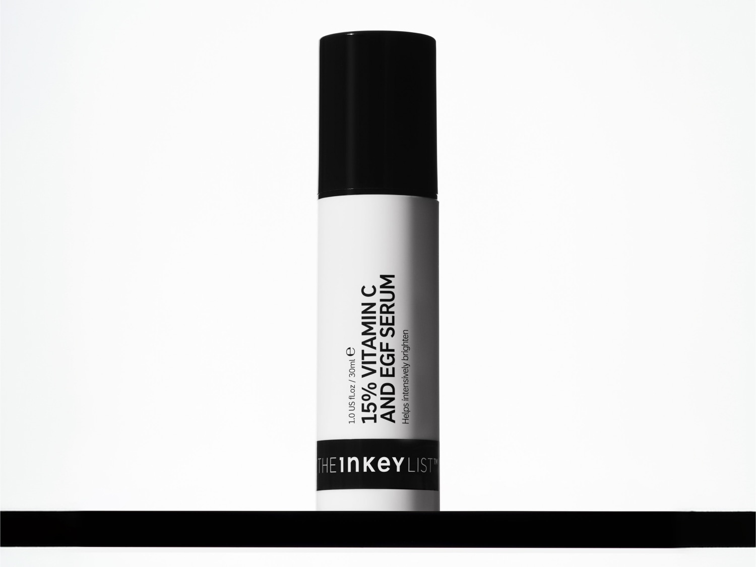 Eine weiße Flasche des The Inkey List 15 % Vitamin C und EGF Serums mit schwarzem Deckel und schwarzem Etikett seht auf einem schwarzen Untergrund.