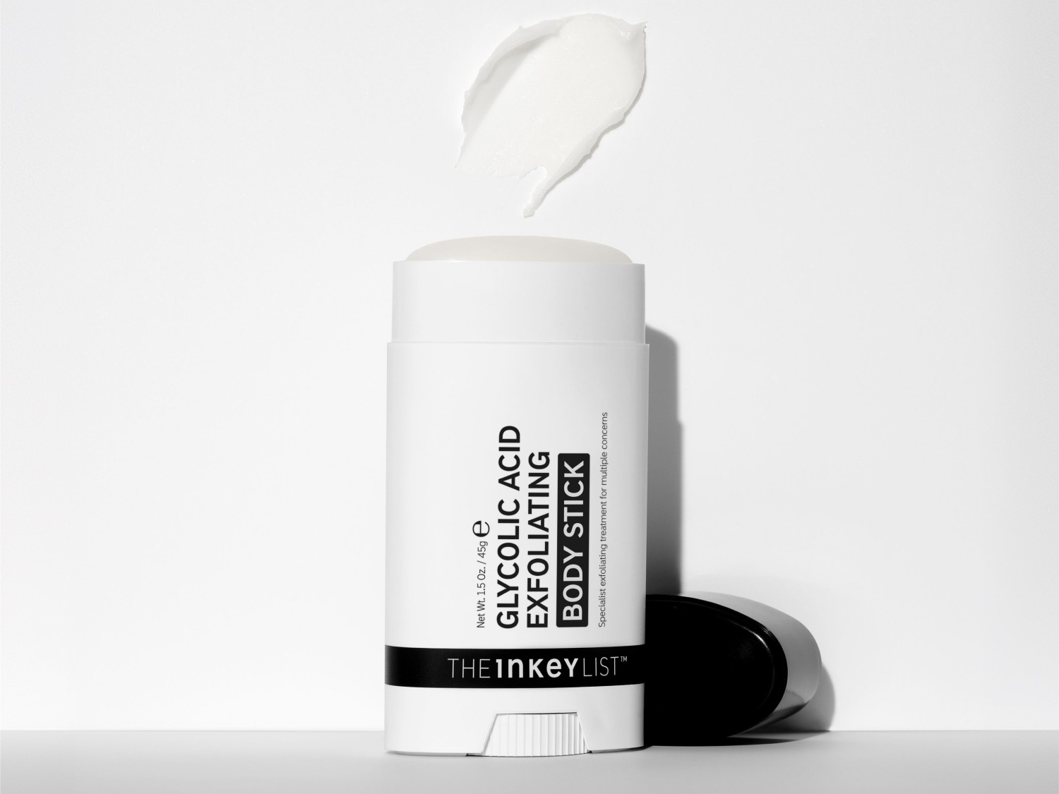 Der Glycolic Acid Exfoliating Body Stick von The Inkey List ist ein weißer Stick mit schwarzer Schrift, der auf einem weißen Hintergrund steht und eine cremige Textur zeigt.