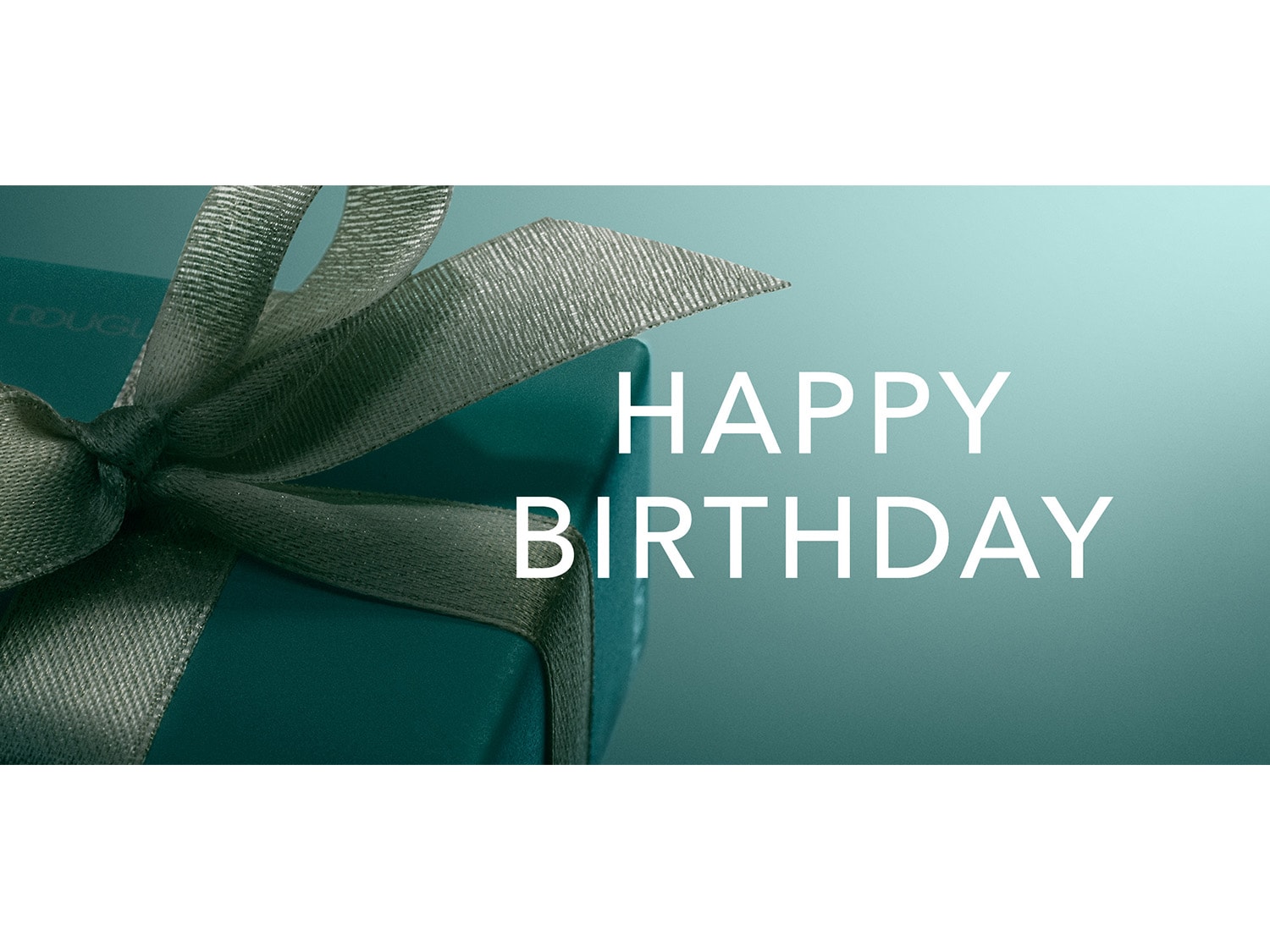 Une boîte cadeau bleu sarcelle avec un ruban vert foncé et le texte "JOYEUX ANNIVERSAIRE" en blanc sur un fond bleu sarcelle.