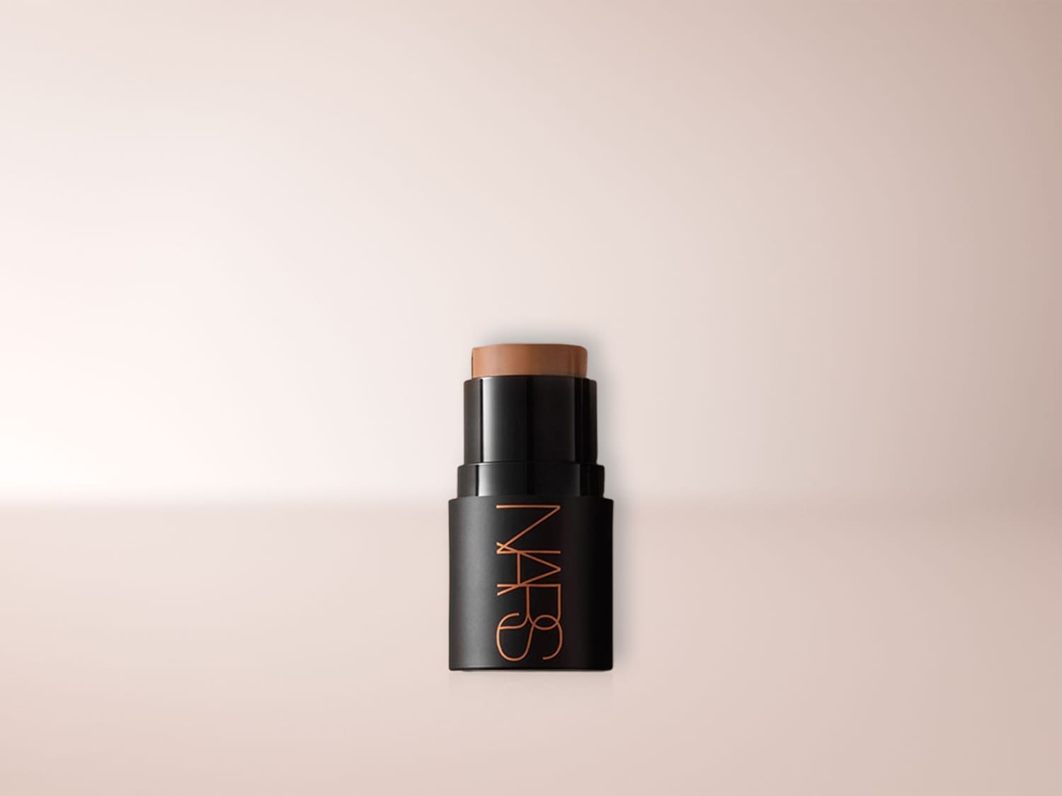 Der NARS Foundation Stick in einem eleganten schwarzen Gehäuse mit goldener Schrift, der eine cremige, braune Textur für ein makelloses Finish zeigt.
