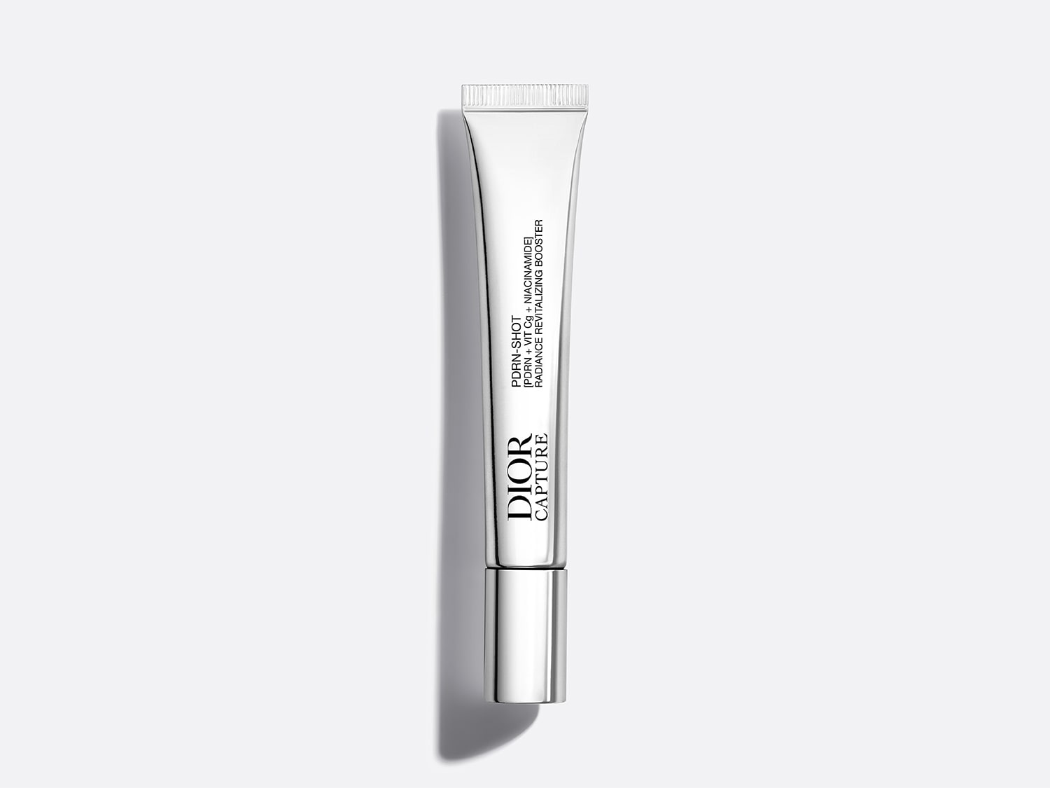 Le booster revitalisant éclat PDRN-SHOT de Dior Capture, un tube blanc élégant avec un capuchon argenté, est formulé avec du PDRN, de la vitamine Cg et du niacinamide pour une peau radieuse.