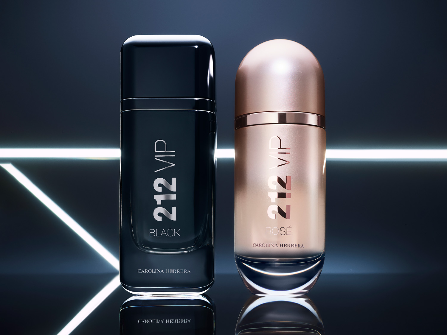 Dvě lahvičky parfému Carolina Herrera 212 VIP, jedna černá s nápisem "BLACK" a druhá růžovo-zlatá s nápisem "ROSÉ", stojí na lesklém povrchu s bílými světelnými pruhy v pozadí.