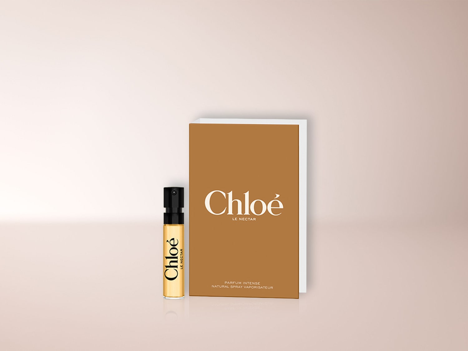 Ein goldener Chloé Le Nectar Parfum Intense Zerstäuber und eine passende goldene Verpackung stehen auf einem hellrosa Hintergrund.