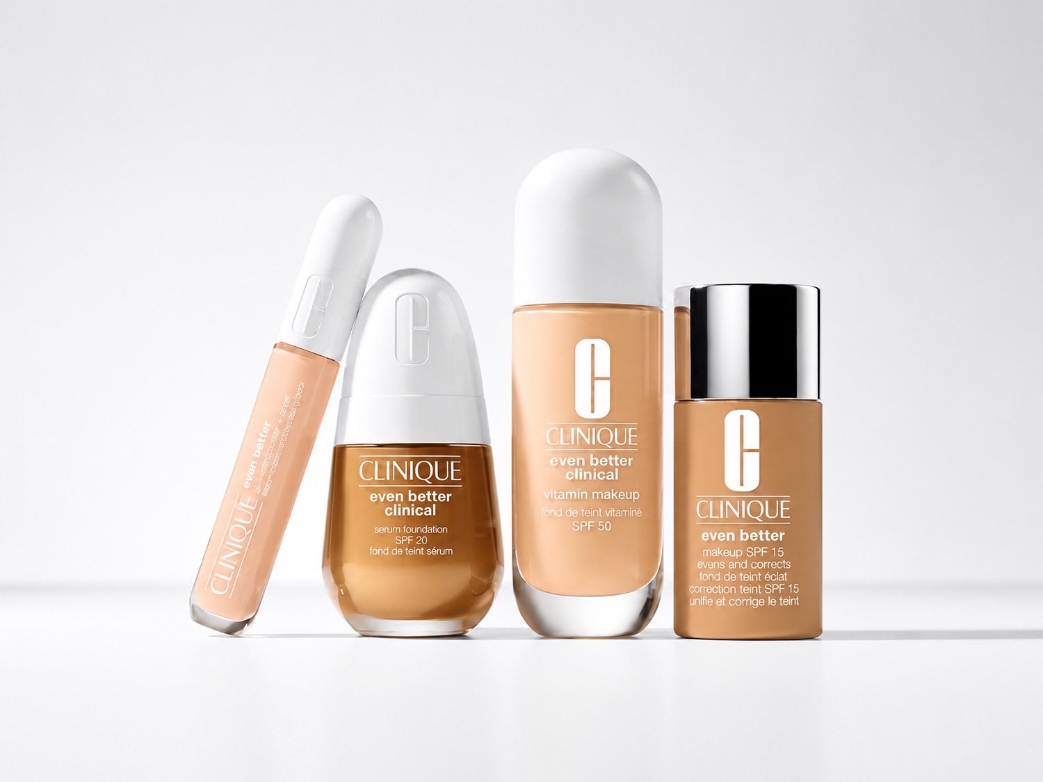 Una collezione di prodotti Clinique Even Better, tra cui un correttore, un fondotinta siero SPF 20, un fondotinta vitaminico SPF 50 e un fondotinta uniformante SPF 15, tutti in tonalità beige.