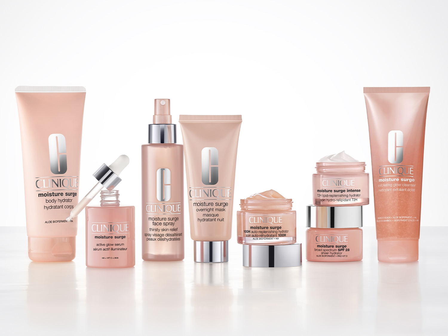 Una collezione di prodotti Clinique Moisture Surge in confezioni rosa chiaro, tra cui un idratante corpo, un siero illuminante, uno spray viso, una maschera notte, un idratante 100H, un idratante intenso, un detergente esfoliante e un idratante con SPF 28.