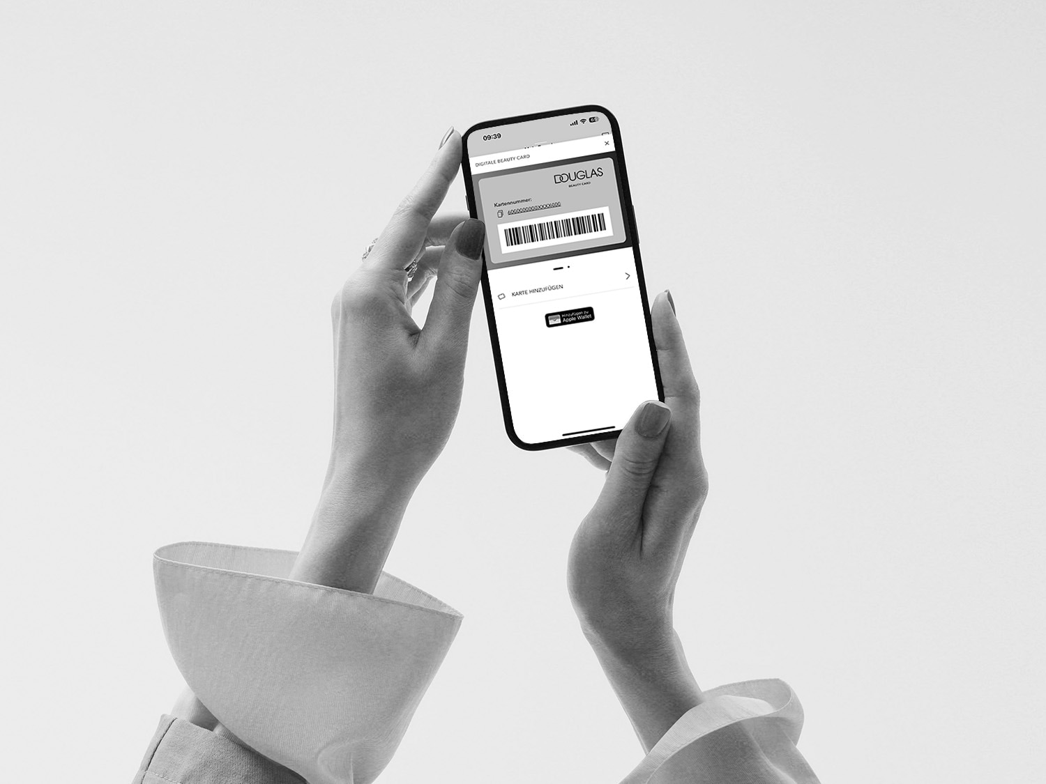Žena drží chytrý telefon s aplikací Douglas Beauty Card, která zobrazuje čárový kód a možnost přidat kartu do Apple Wallet.