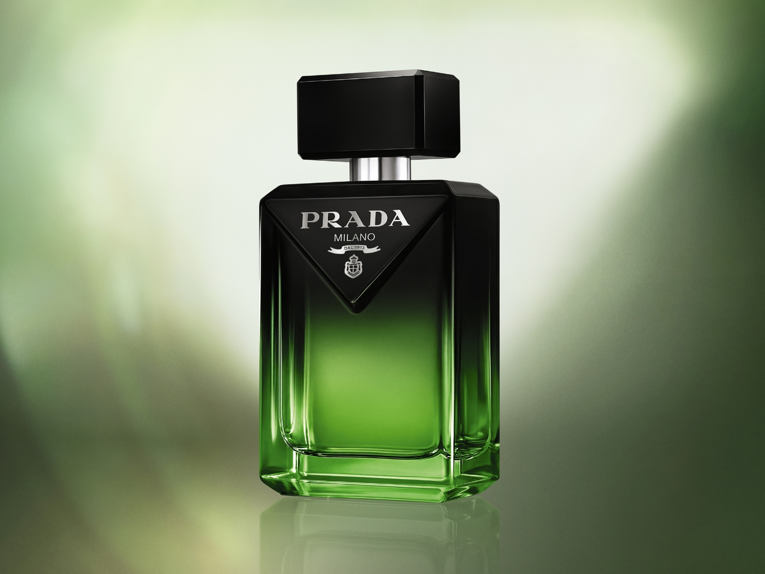 Prada Luna Rossa Ocean Eau de Toilette je elegantní flakon s černým víčkem a stříbrným rozprašovačem, který přechází z tmavě zelené do světle zelené barvy, s logem Prada Milano uprostřed.