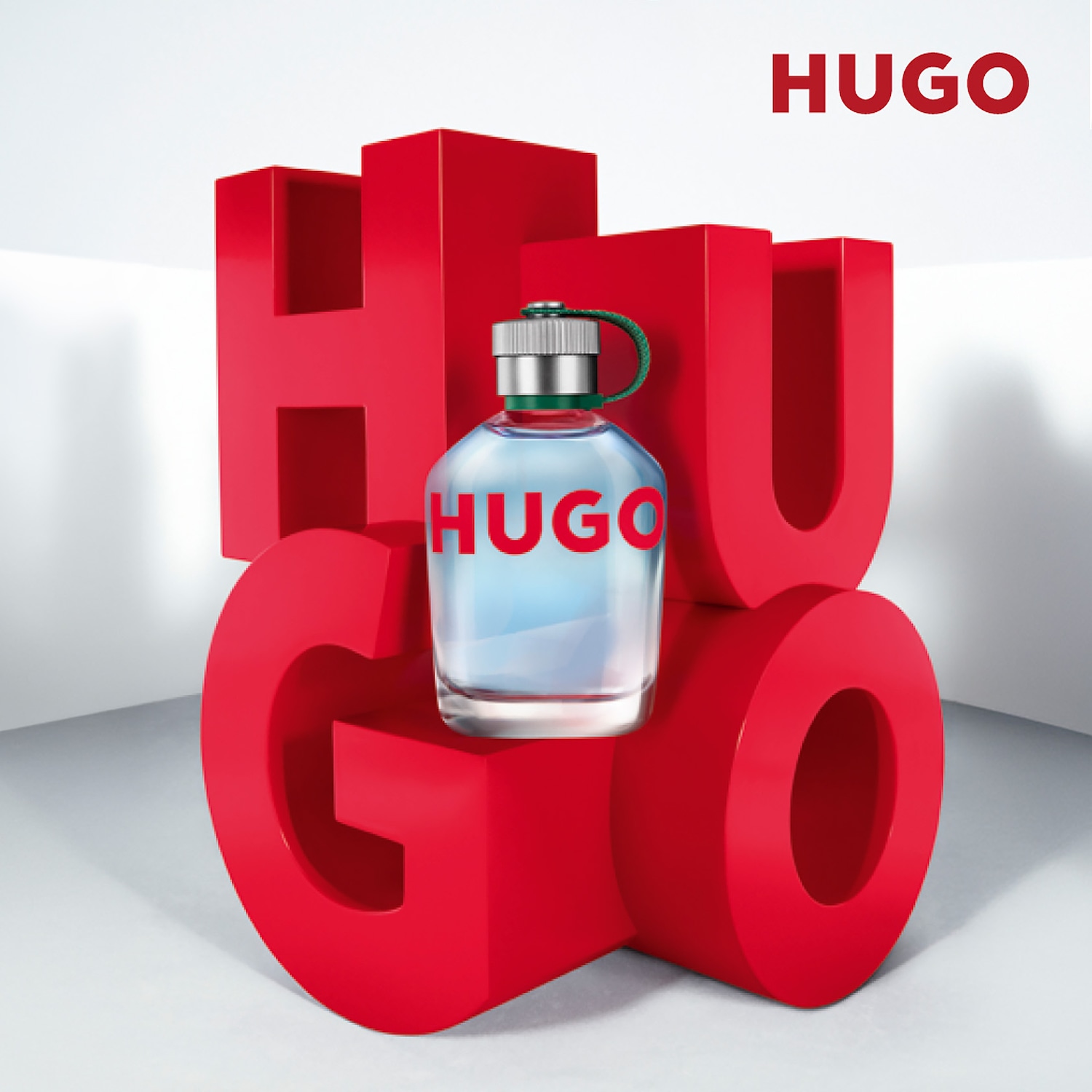 Parfum Hugo Man v priehľadnej fľaši s modrou tekutinou a strieborným uzáverom, obklopený veľkými červenými písmenami tvoriacimi slovo HUGO, ktoré sú umiestnené na bielom pozadí.