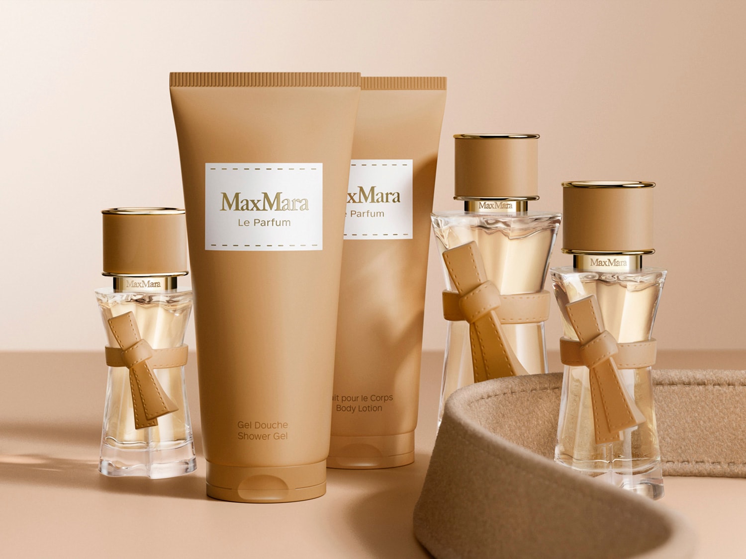 El set de regalo Max Mara Le Parfum incluye un gel de ducha, una loción corporal y dos botellas de perfume, todos en envases de color beige con detalles dorados y lazos decorativos.