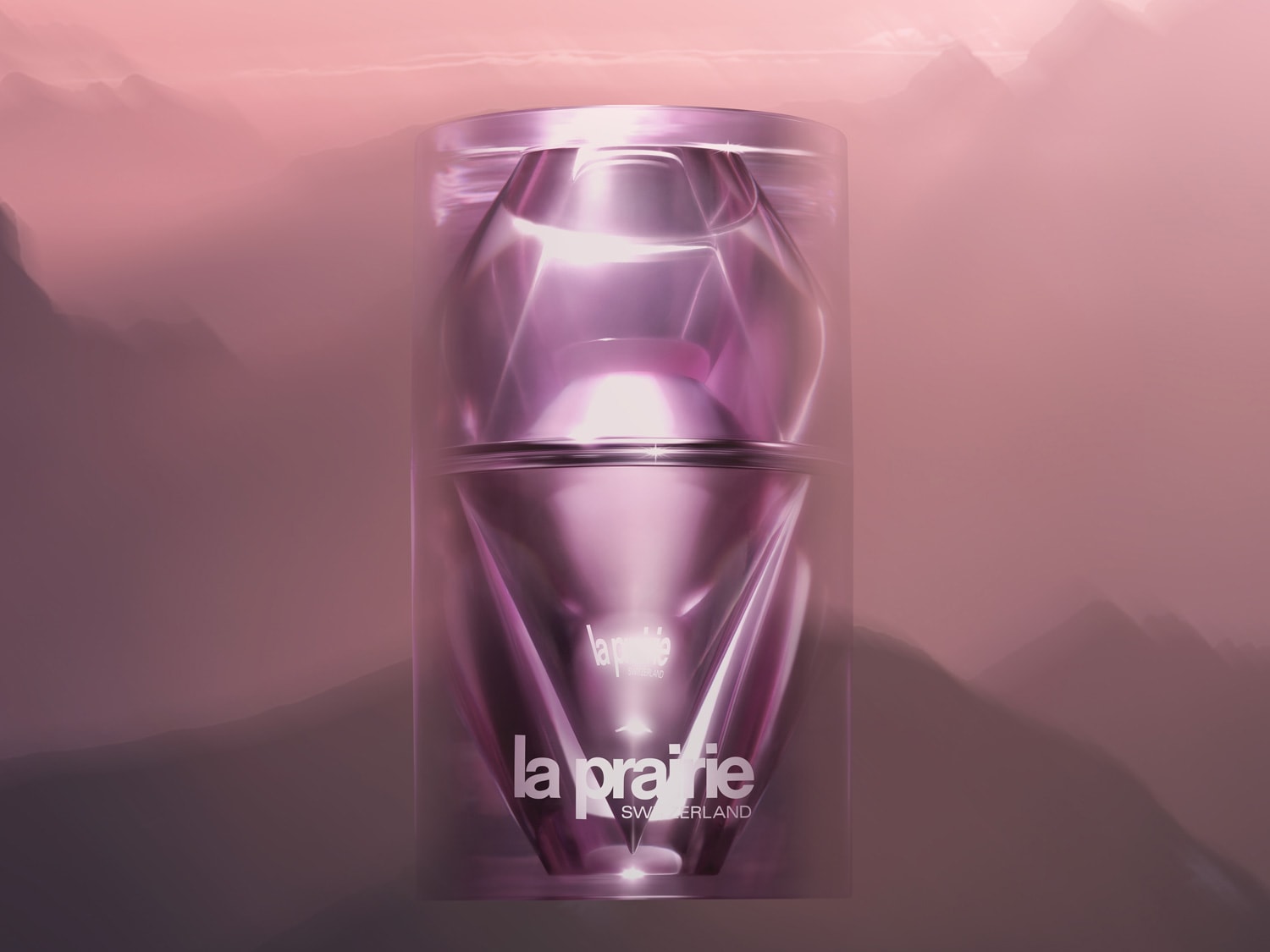 La Prairie Switzerland pleťový krém v průhledném obalu s růžovým nádechem, který připomíná drahokam, na pozadí s horami v mlze.