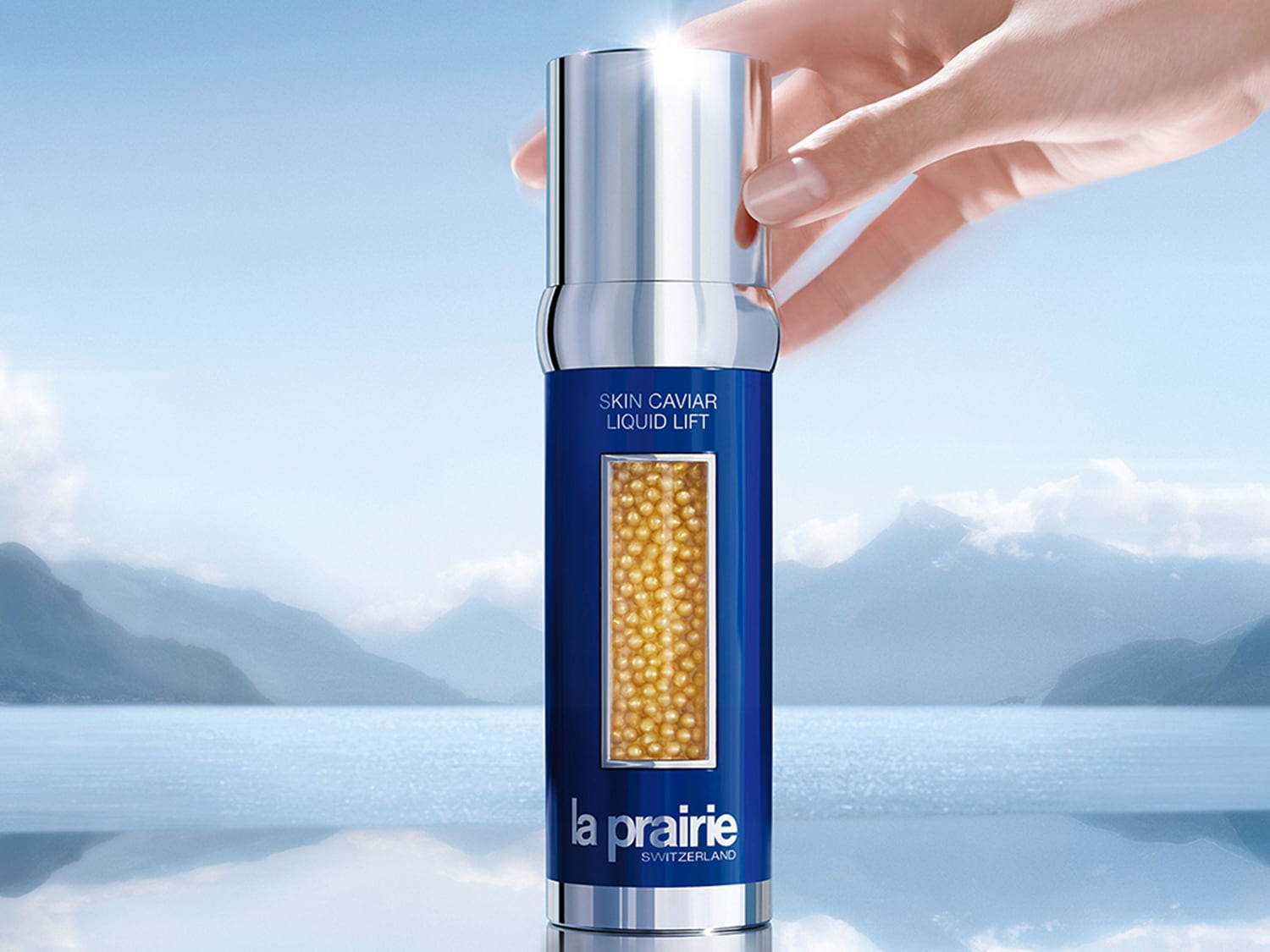 Lahvička La Prairie Skin Caviar Liquid Lift v modro-stříbrném balení s okénkem plným zlatavých perliček, které slibují liftingový efekt.