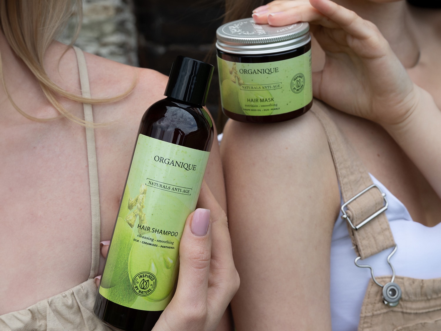 Butelka szamponu do włosów Organique Naturals Anti-Age z zieloną etykietą, obok słoiczek maski do włosów, obydwa produkty obiecują odżywienie i wygładzenie.