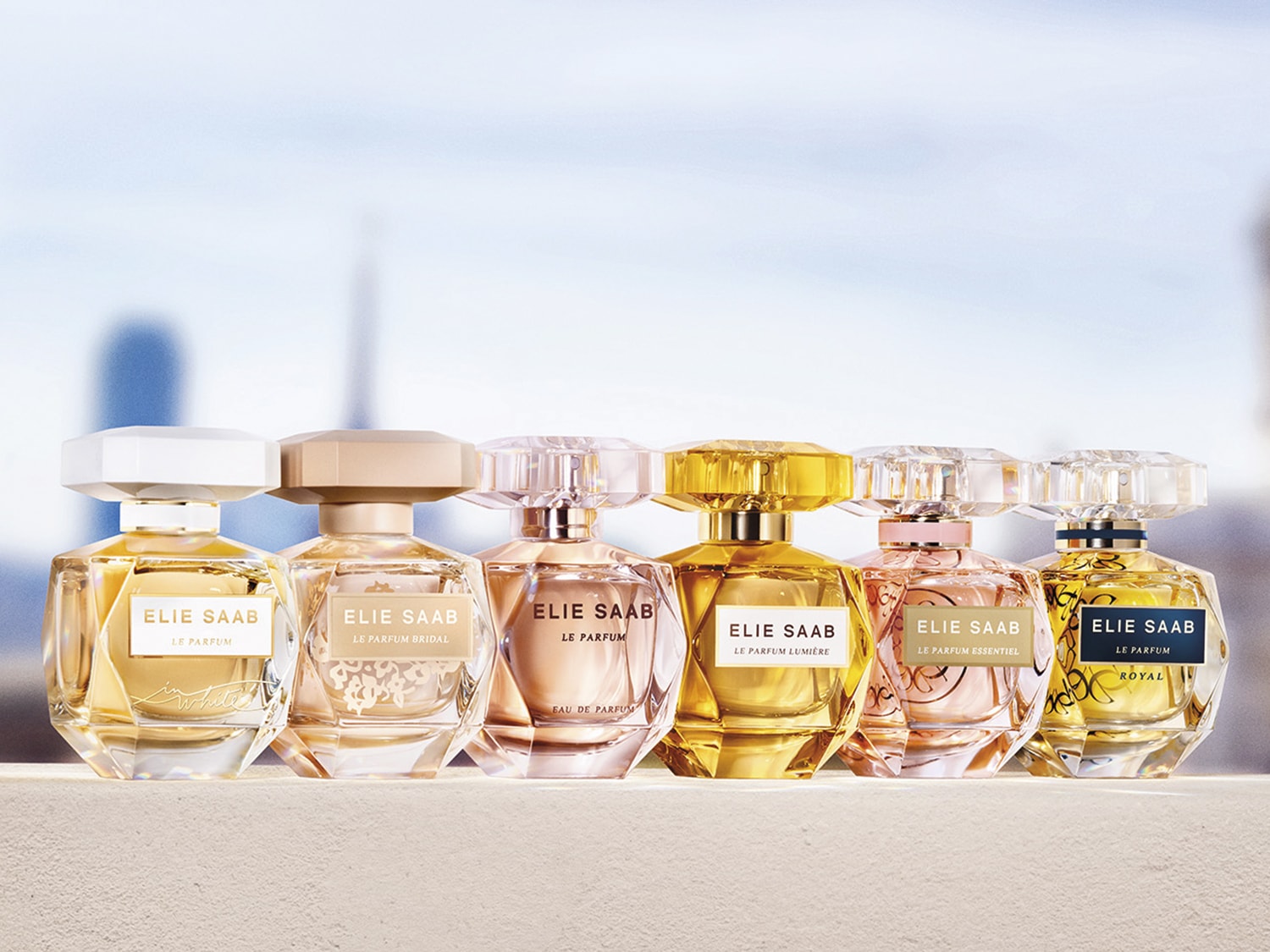 Kolekcja perfum Elie Saab prezentuje różnorodne zapachy w eleganckich flakonach o różnych odcieniach złota i różu, idealne na każdą okazję.