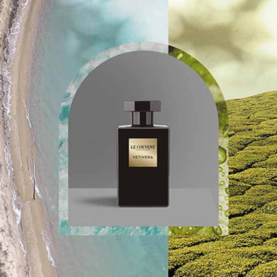 Czarna butelka perfum Le Couvent Vetivera na tle plaży i zielonych wzgórz, emanująca świeżością i naturalnym aromatem.