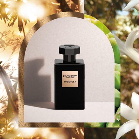 Czarny flakon perfum Le Couvent Tuberosa na tle kwiatów i roślin, emanujący elegancją i głębią zapachu.