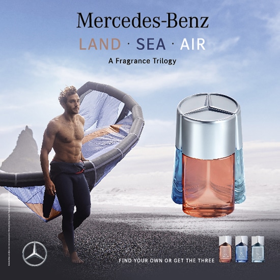 Mercedes-Benz prezentuje trylogię zapachową LAND, SEA, AIR, flakon perfum w odcieniach błękitu i brzoskwini, obok mężczyzna z latawcem na tle plaży. Znajdź swój zapach lub zdobądź wszystkie trzy.