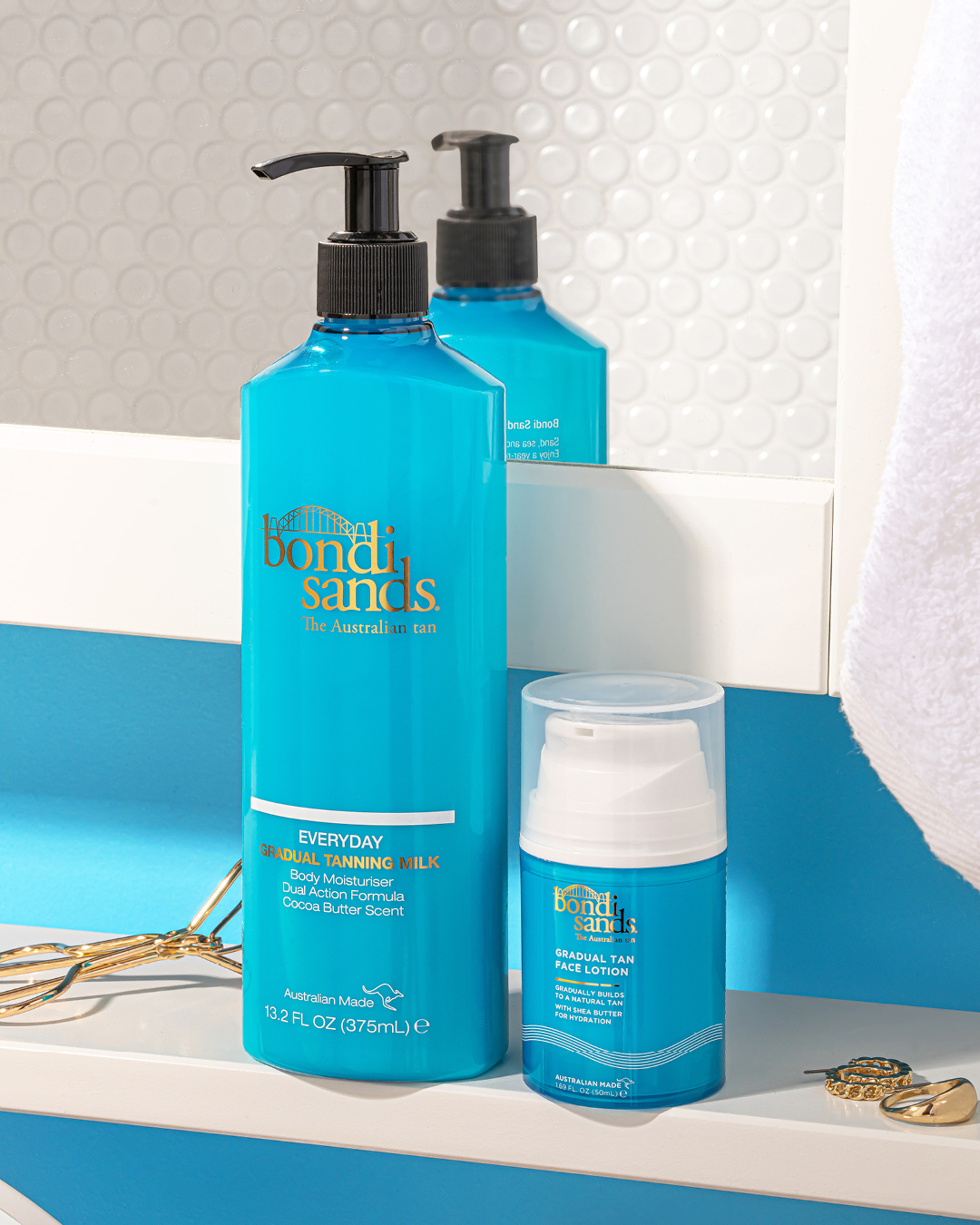 De blauwe flessen Bondi Sands Everyday Gradual Tanning Milk en Face Lotion staan op een plank, klaar om je huid een natuurlijke, zonovergoten gloed te geven.