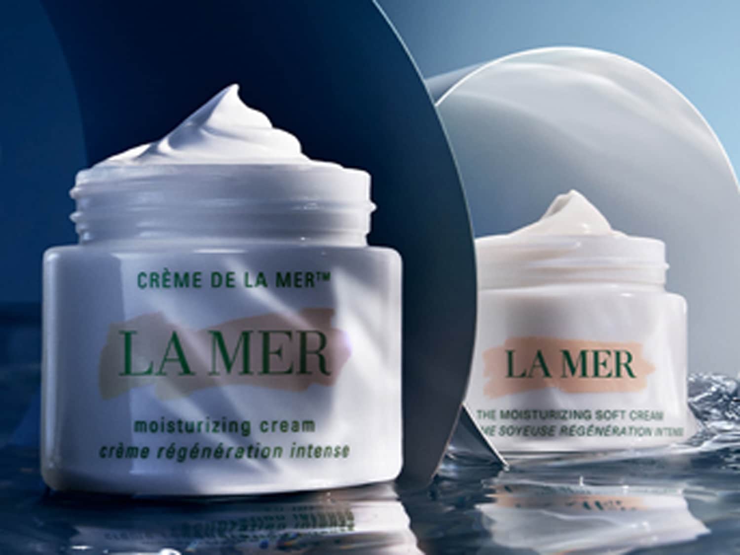 Twee potten La Mer crème, de ene is een hydraterende crème en de andere is een hydraterende zachte crème, beide in een witte verpakking.