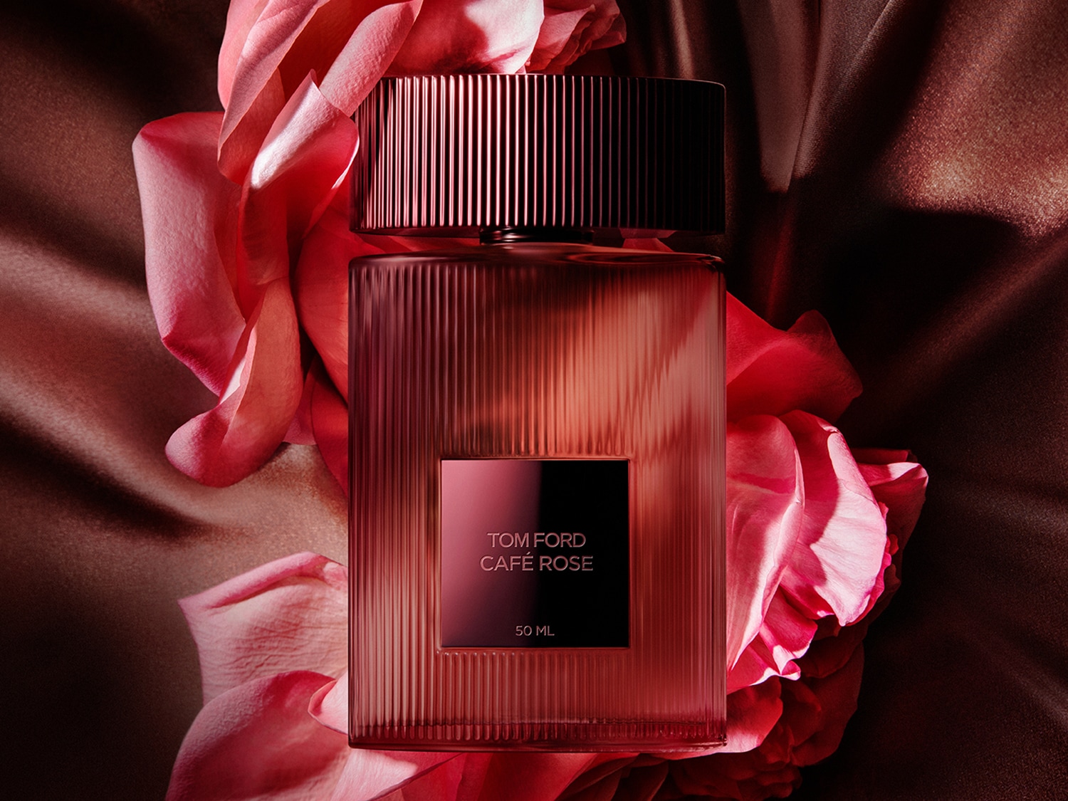 Tom Ford Café Rose 50ml parfumfles, gehuld in een roze tint, omringd door zachte rozenblaadjes.