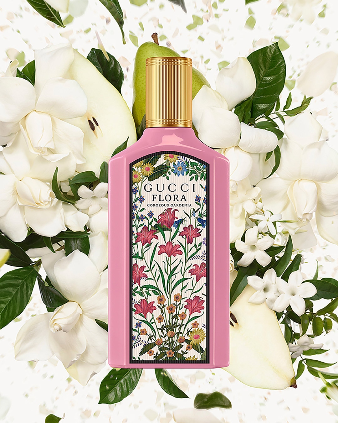 Różowy flakon Gucci Flora Gorgeous Gardenia otoczony białymi kwiatami i zielonymi liśćmi, z nutą gruszki, tworzący świeżą i kwiatową kompozycję.