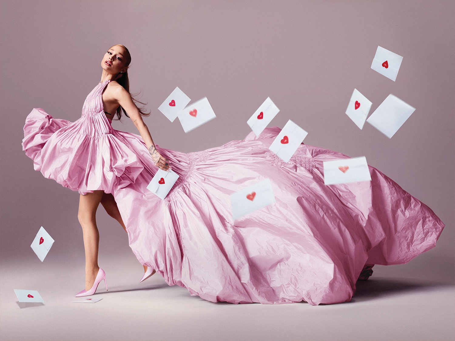Kobieta w różowej sukni otoczona białymi kopertami z czerwonymi sercami, emanująca romantyczną i uroczystą atmosferą.
