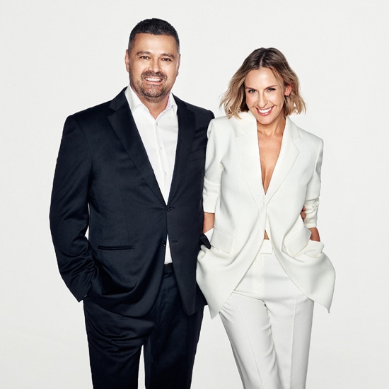 Zdjęcie przedstawia uśmiechniętą kobietę w białym garniturze i mężczyznę w czarnym garniturze, stojących obok siebie na jasnym tle.