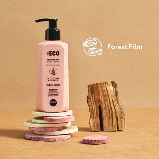 Różowa butelka szamponu Be Eco Pure Volume z czarną pompką, stoi na drewnianych krążkach obok kawałka drewna, obok napis Forest Film.