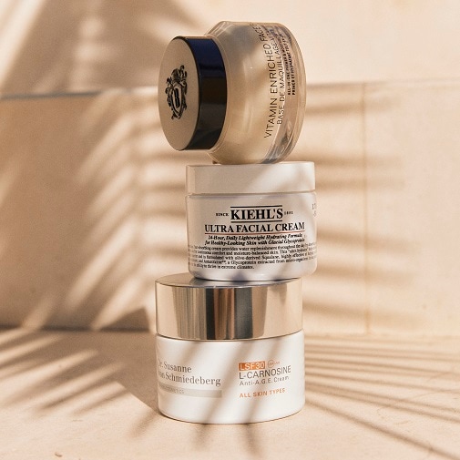 Na zdjęciu widać piramidę z trzech kremów do twarzy różnych marek, w tym Kiehl's Ultra Facial Cream i Dr. Susanne von Schmiedeberg L-Carnosine Anti-Age Cream.