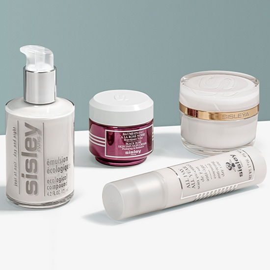 Kolekcja kosmetyków Sisley do pielęgnacji skóry, w tym emulsja ekologiczna w białej butelce z pompką, krem na dzień All Year w tubce i krem na noc Black Rose w bordowym słoiczku.