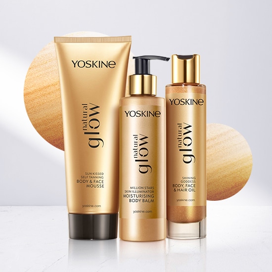 Zestaw Yoskine Natural Glow w złotych opakowaniach: samoopalający mus do ciała i twarzy, balsam nawilżający i rozświetlający skórę oraz olejek do ciała, twarzy i włosów.