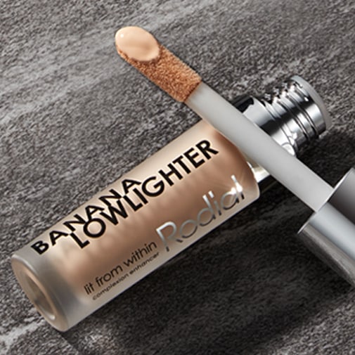 Rodial Banana Lowlighter w odcieniu banana, z aplikatorem z kremowym korektorem, który rozświetla cerę.