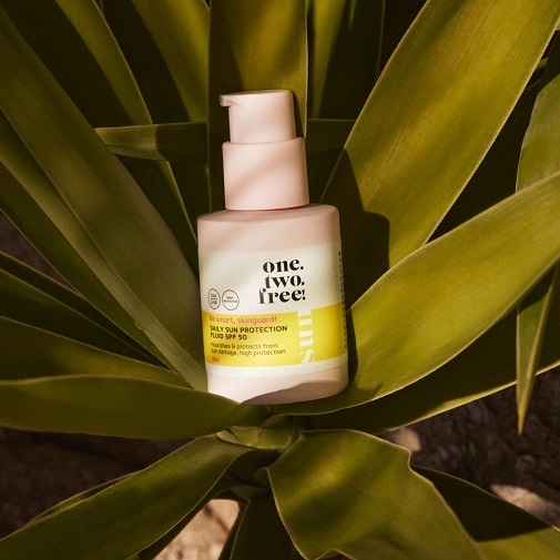 Aquí tienes el protector solar diario fluido SPF 50 de one.two.free! en un envase rosa y blanco, que nutre y protege tu piel del daño solar.