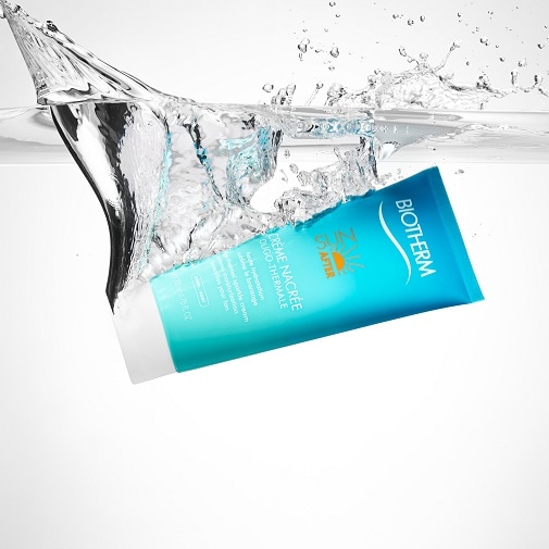 A turquoise tube of Biotherm Crème Nacrée is splashed with water, promising intense hydration and a luminous complexion.