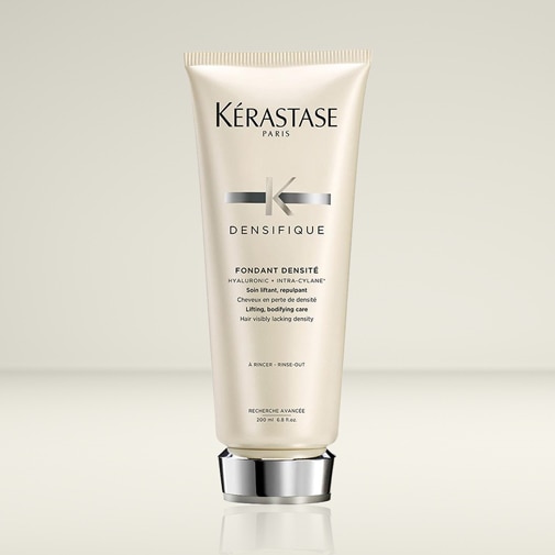 Die hellbeige Tube Kérastase Paris Densifique Fondant Densité Haarpflege mit silbernem Verschluss verspricht Lifting und mehr Fülle für kraftloses Haar.