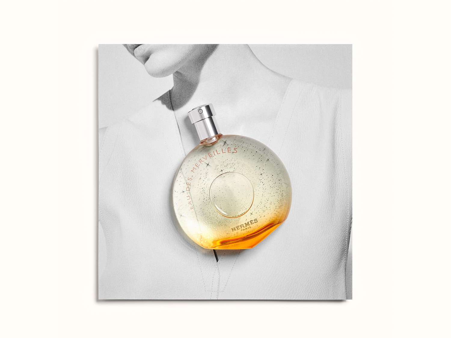 El frasco redondo de Eau des Merveilles de Hermès, con su líquido que se degrada de transparente a ámbar, evoca un mundo de fantasía y lujo.