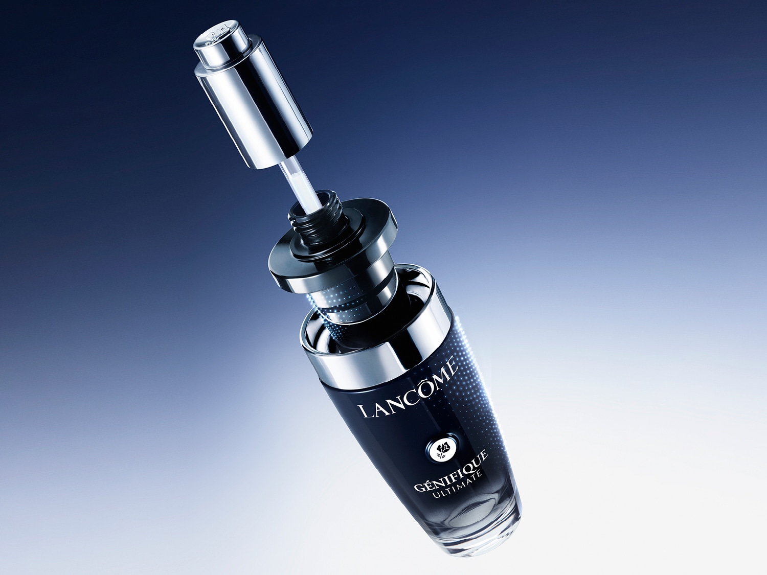 El sérum Lancôme Génifique Ultimate, en un frasco de cristal oscuro con letras blancas y un aplicador plateado, se eleva sobre un fondo azul degradado.