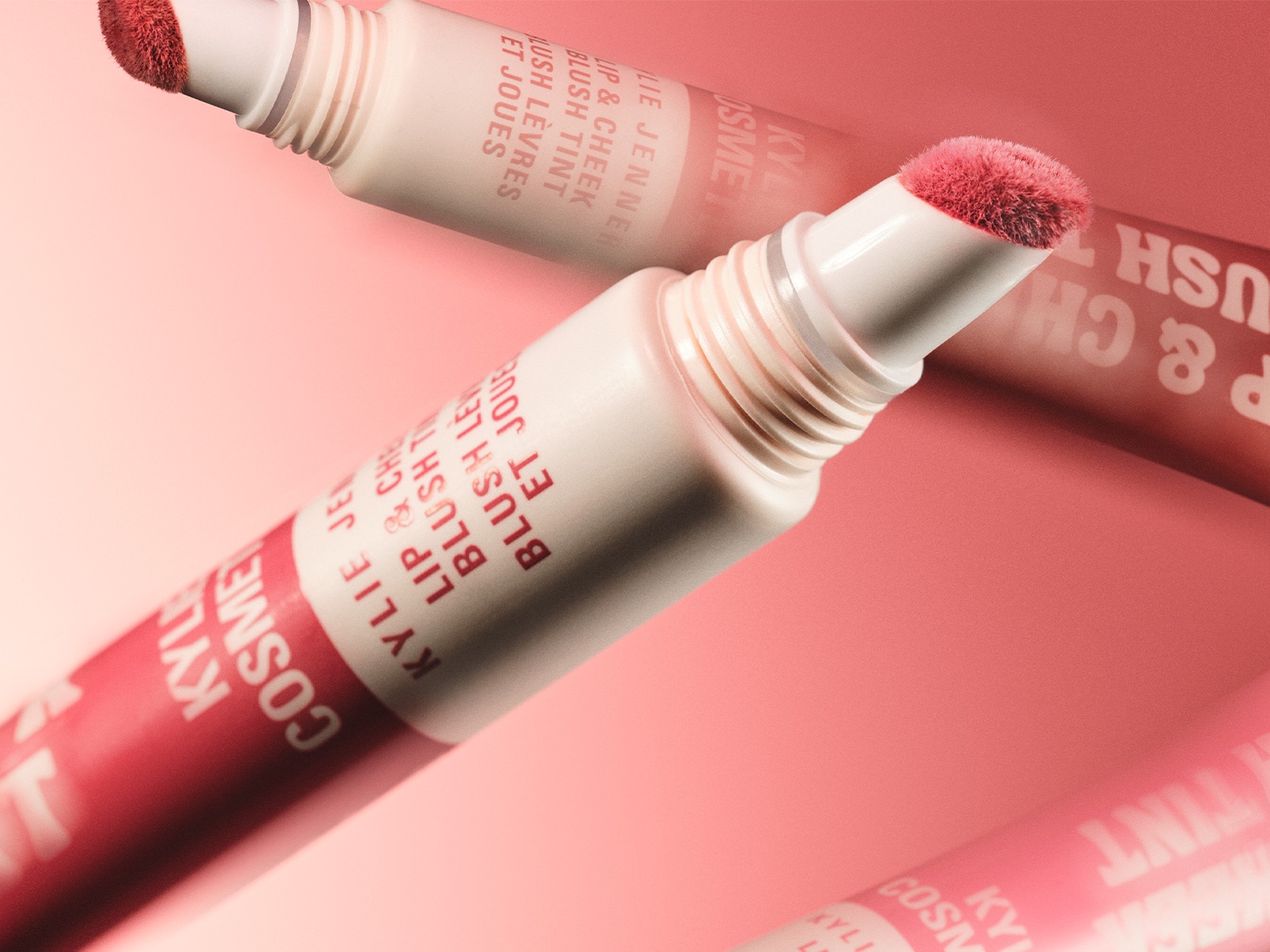 Błyszczyk do ust i policzków Kylie Cosmetics w odcieniach różu, z aplikatorem w formie pędzelka, idealny do makijażu.