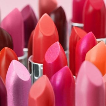 Nahaufnahme von Lippenstiften in verschiedenen Rot-, Rosa- und Lilatönen, die eine vielfältige Auswahl an Farben für jeden Hautton und Anlass bieten.