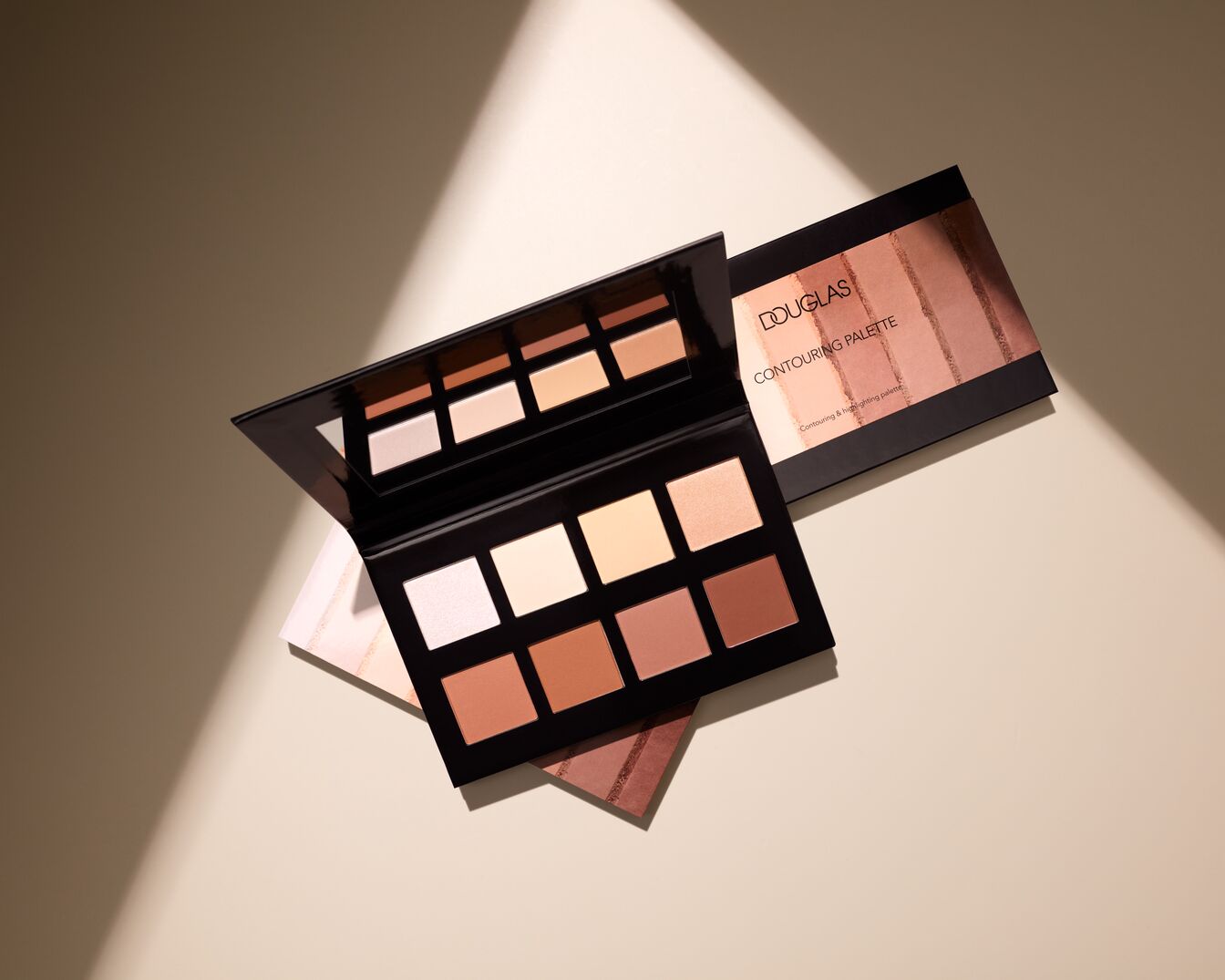 Paleta do konturowania Douglas z ośmioma odcieniami w pudrze, od jasnych po ciemne brązy, w czarnym, błyszczącym opakowaniu z lusterkiem.