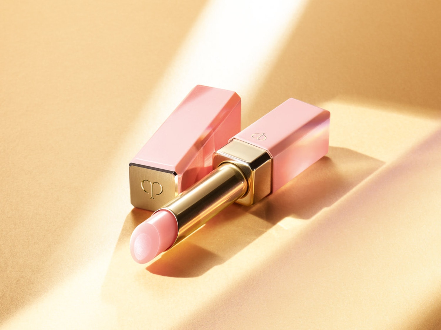 Découvrez un rouge à lèvres rose pâle avec un étui assorti et des accents dorés, offrant une touche de luxe et d'élégance à votre routine beauté.