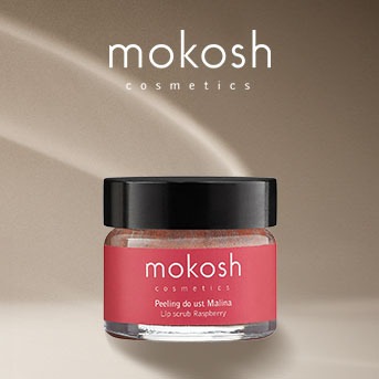 Słoik z peelingiem do ust Mokosh o zapachu malin, z różową etykietą i czarną nakrętką, na beżowym tle.